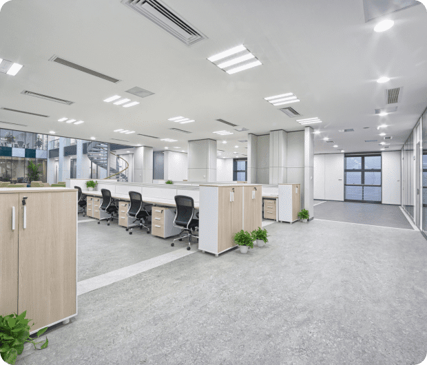 Modern open-plan office with workstations and plants.