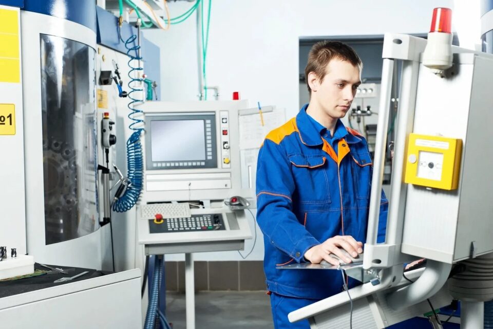 Technician operating machinery in industrial setting.